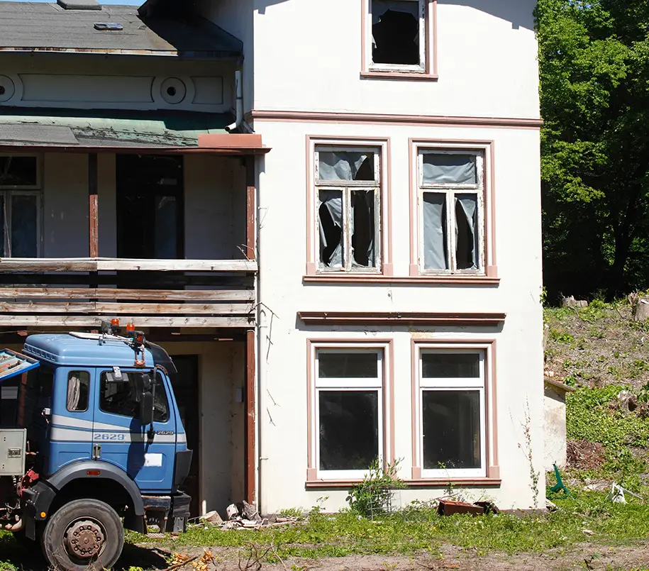 Lastwagen vor einem abbruchreifen Wohnhaus