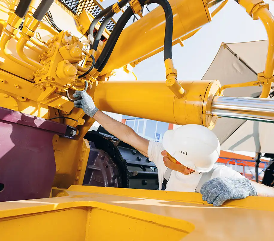 Bauarbeiter bei der Wartung einer Baumaschine