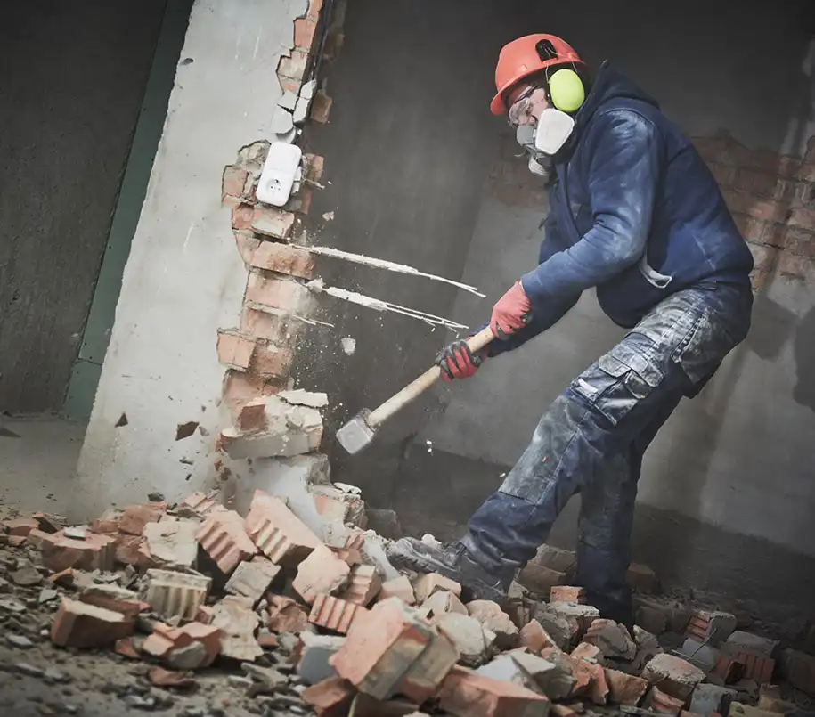 Bauarbeiter beim Abriss mit Abbruchhammer in einem Gebäude