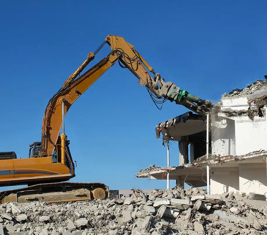 Bagger beim Abriss vor blauem Himmel